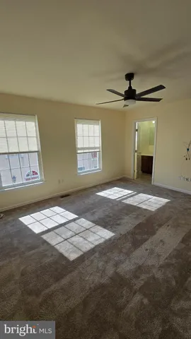 a view of an empty room with a window and fireplace