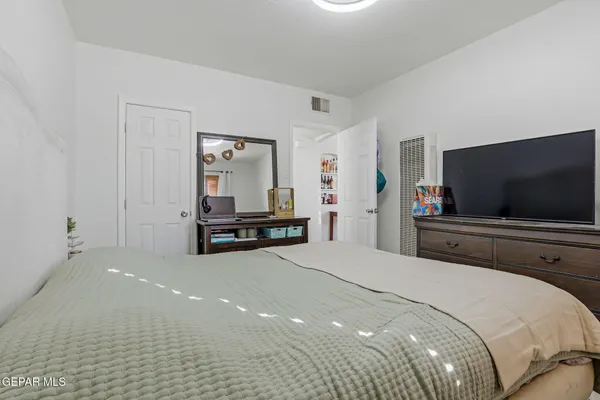 a bedroom with a bed and a flat screen tv