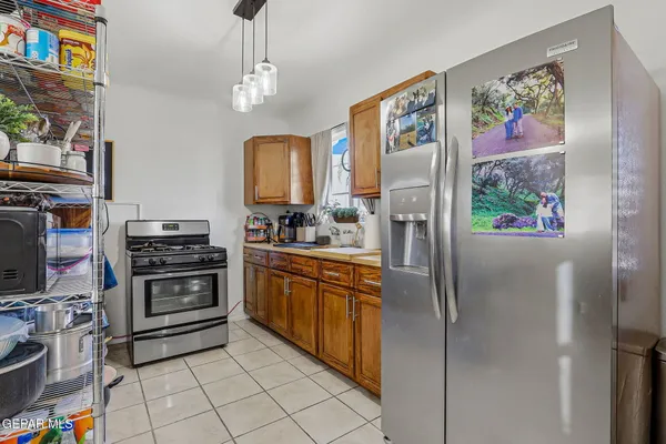 a kitchen with stainless steel appliances granite countertop a refrigerator and a stove top oven