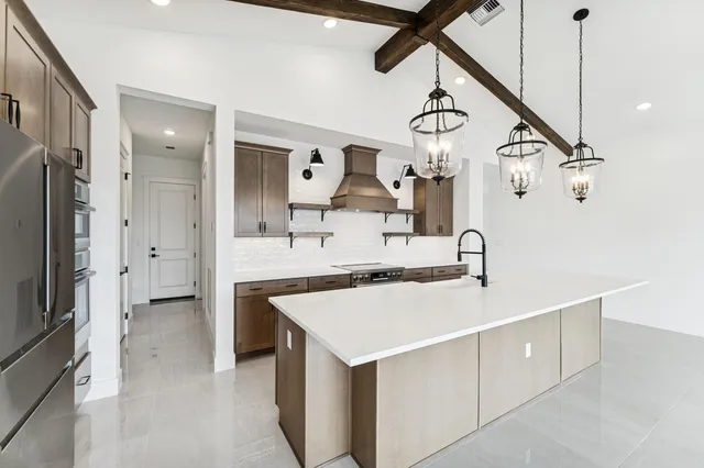 a kitchen with a sink a counter top space and stainless steel appliances