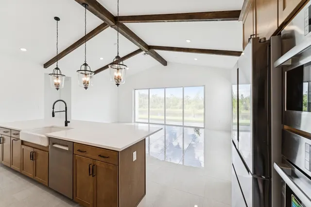 a view of kitchen with stainless steel appliances kitchen island large natural light
