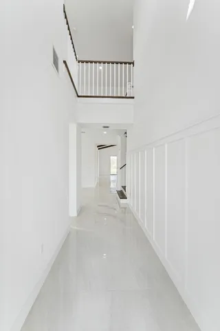 a view of staircase with white walls and fan