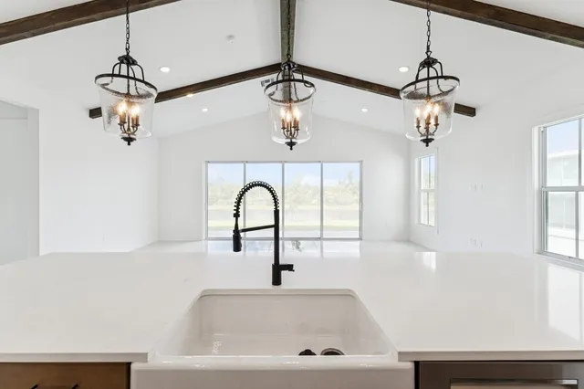 a large white kitchen with a lot of counter space and wooden floor