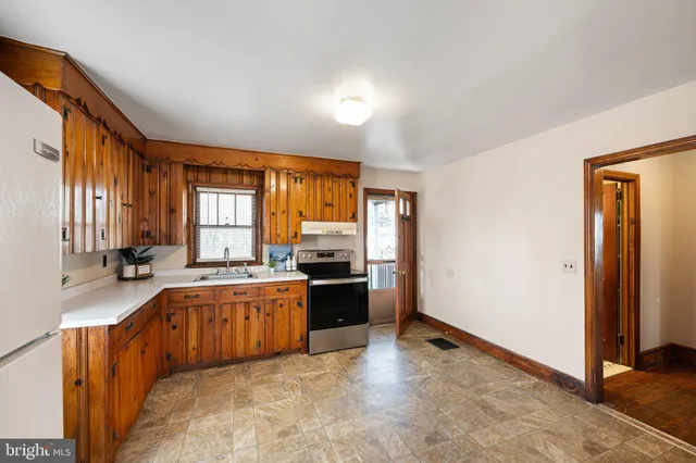 a large kitchen with a stove a sink dishwasher and a refrigerator