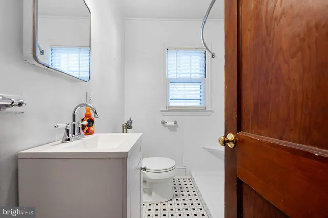 a bathroom with a sink toilet and a window