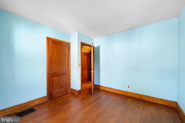 an empty room with wooden floor and closet