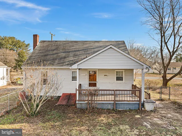a view of a house with a yard and wooden fence