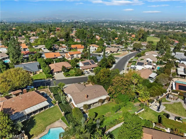 an aerial view of a house with a yard fire pit and outdoor seating