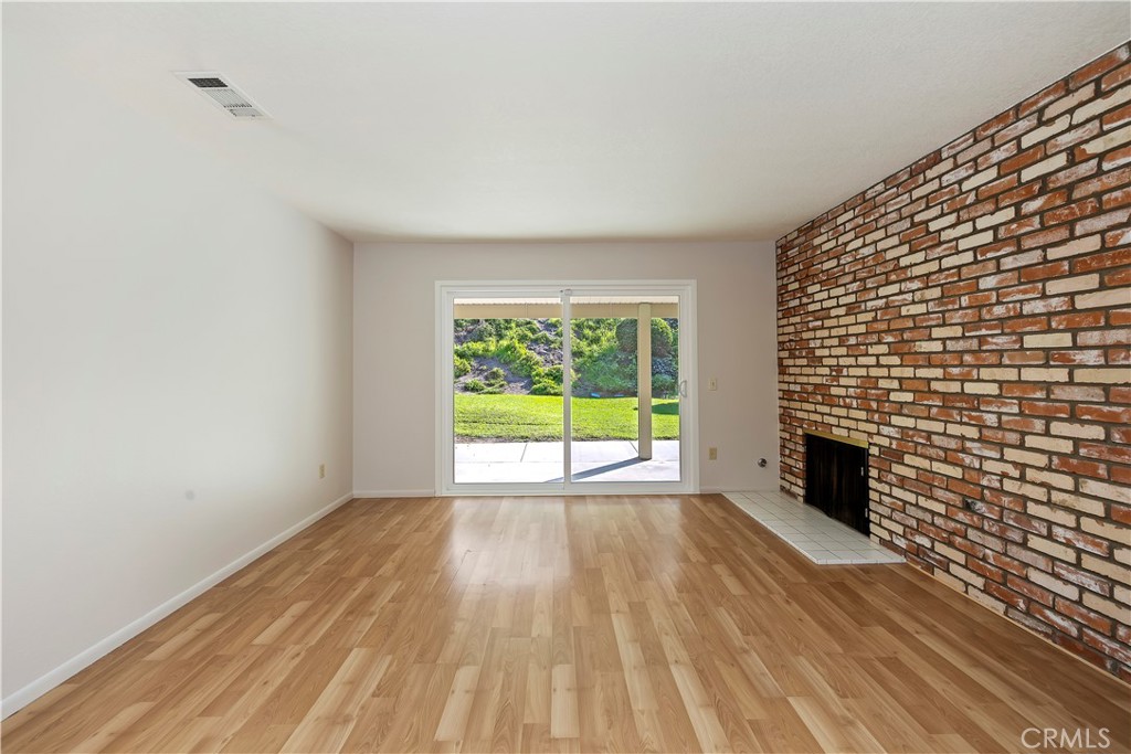 1440 Trenton Drive Riverside, CA 92506 - Photo 9 of 52 a view of empty room with wooden floor and fireplace
