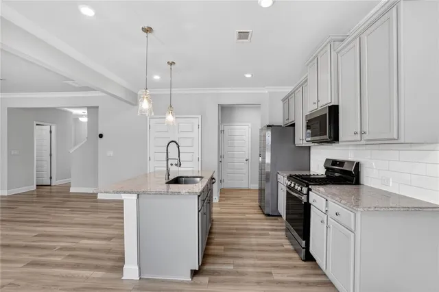 a kitchen with stainless steel appliances granite countertop a sink stove and refrigerator