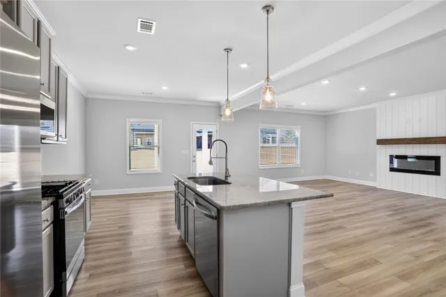 a kitchen with granite countertop a stove and a wooden floor