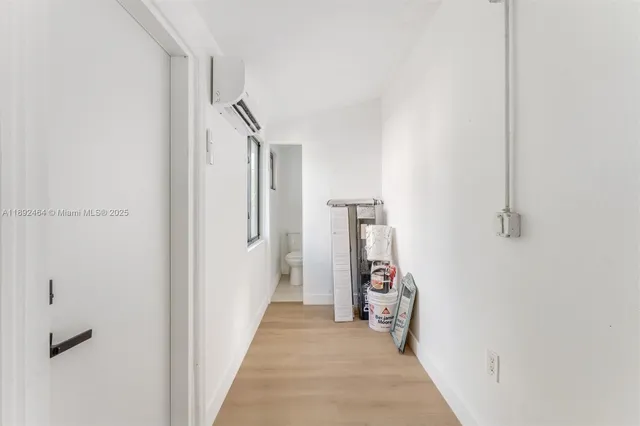 a view of a hallway with white walls and stairs