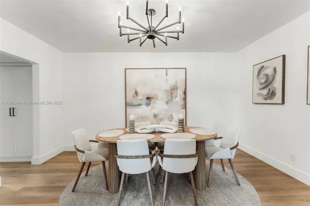 a view of a dining room with furniture a chandelier and wooden floor