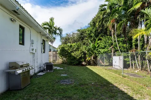 a view of backyard with potted plants and large trees