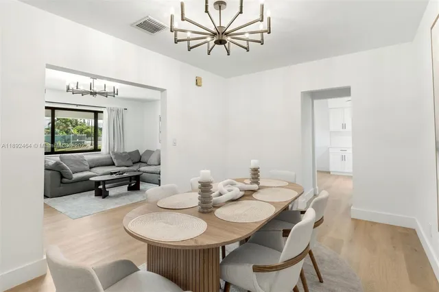 a view of a dining room with furniture and a chandelier