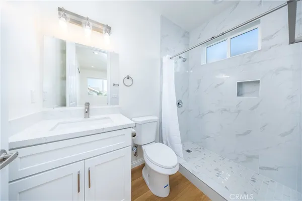 a bathroom with a sink a toilet and shower