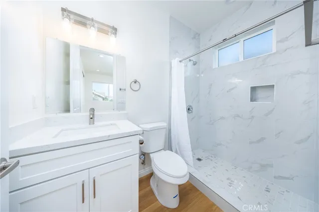 a bathroom with a sink a toilet and shower