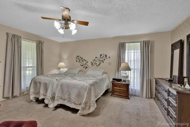 a bedroom with a bed and a flat tv screen on dresser