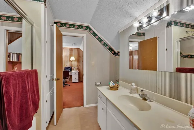 a en suite bathroom with a sink vanity and mirror