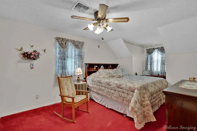 a bed sitting in a spacious bedroom next to a window