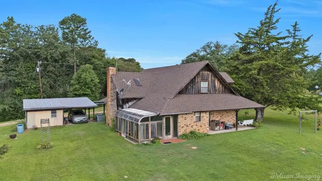 a view of a big house with a big yard and large trees