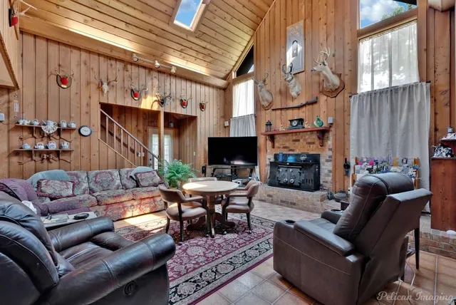 a living room with furniture a fireplace and a large window