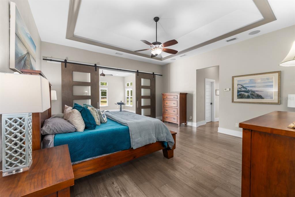 1751 Southwest 188th Street Newberry, FL 32669 - Photo 13 of 93 a spacious bedroom with a bed a couch and a chandelier