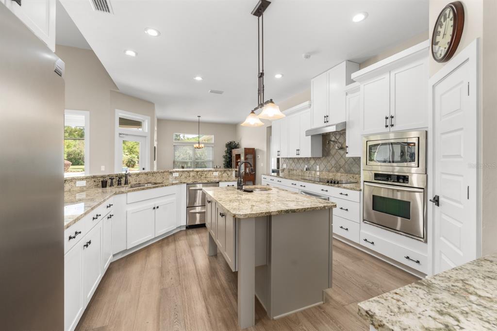 1751 Southwest 188th Street Newberry, FL 32669 - Photo 34 of 93 a kitchen with stainless steel appliances kitchen island granite countertop a stove a sink and a refrigerator