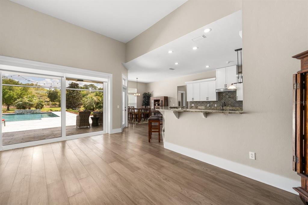 1751 Southwest 188th Street Newberry, FL 32669 - Photo 10 of 93 a view of a living room and kitchen with furniture wooden floor and windows