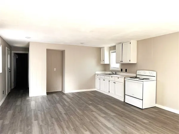a kitchen with granite countertop white cabinets and white appliances