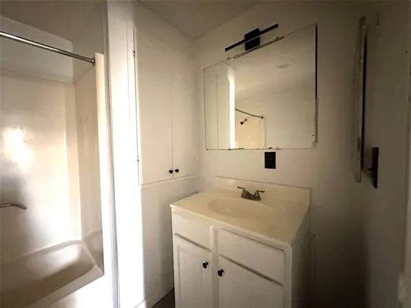 a bathroom with a sink a mirror and shower