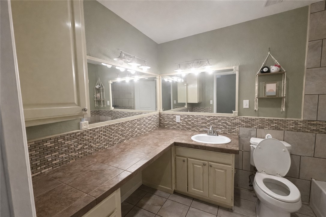 4005 Ridge Trail Robstown, TX 78380 - Photo 13 of 20 a bathroom with a granite countertop toilet sink and mirror