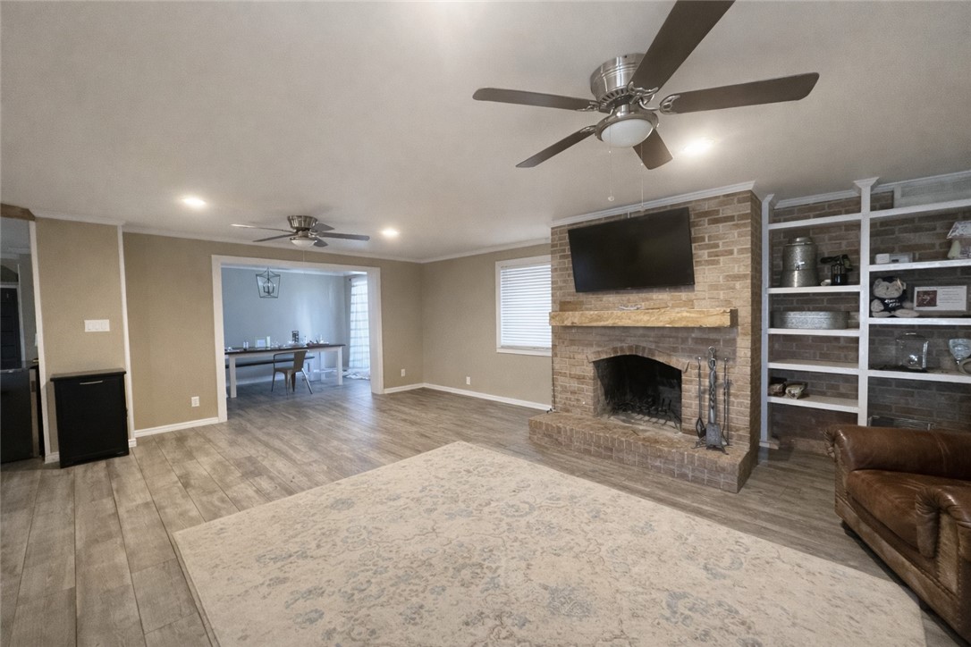 4005 Ridge Trail Robstown, TX 78380 - Photo 8 of 20 a view of a livingroom with a fireplace a ceiling fan and windows