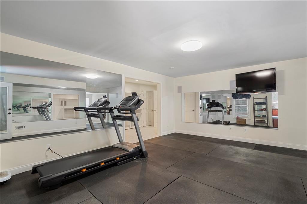 1174 Bowerie Chase Powder Springs, GA 30127 - Photo 49 of 70 a room with gym equipment and a flat screen tv