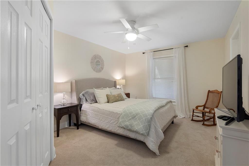 1174 Bowerie Chase Powder Springs, GA 30127 - Photo 54 of 70 a bedroom with a bed tv and a chandelier