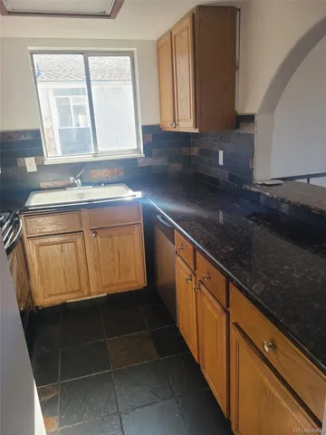 a kitchen with a sink a window and cabinets