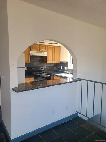 a view of kitchen with stainless steel appliances granite countertop a stove a microwave and a dining table