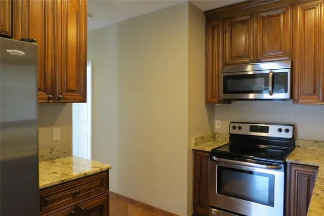 an empty room with wooden floor chandelier fan and windows