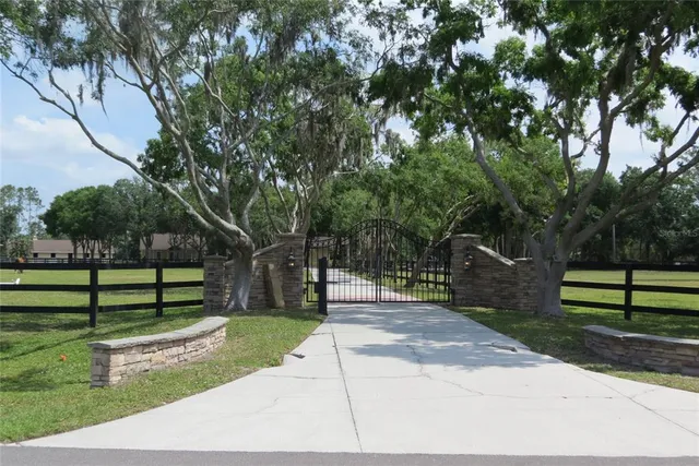 an aerial view of a house with a garden and trees
