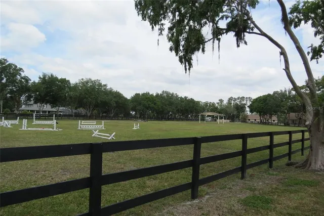 an aerial view of a house with a garden and trees all around