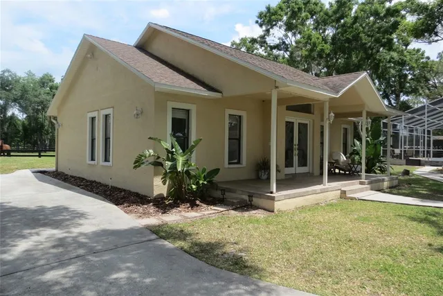 a view of a porch with chairs and potted plants