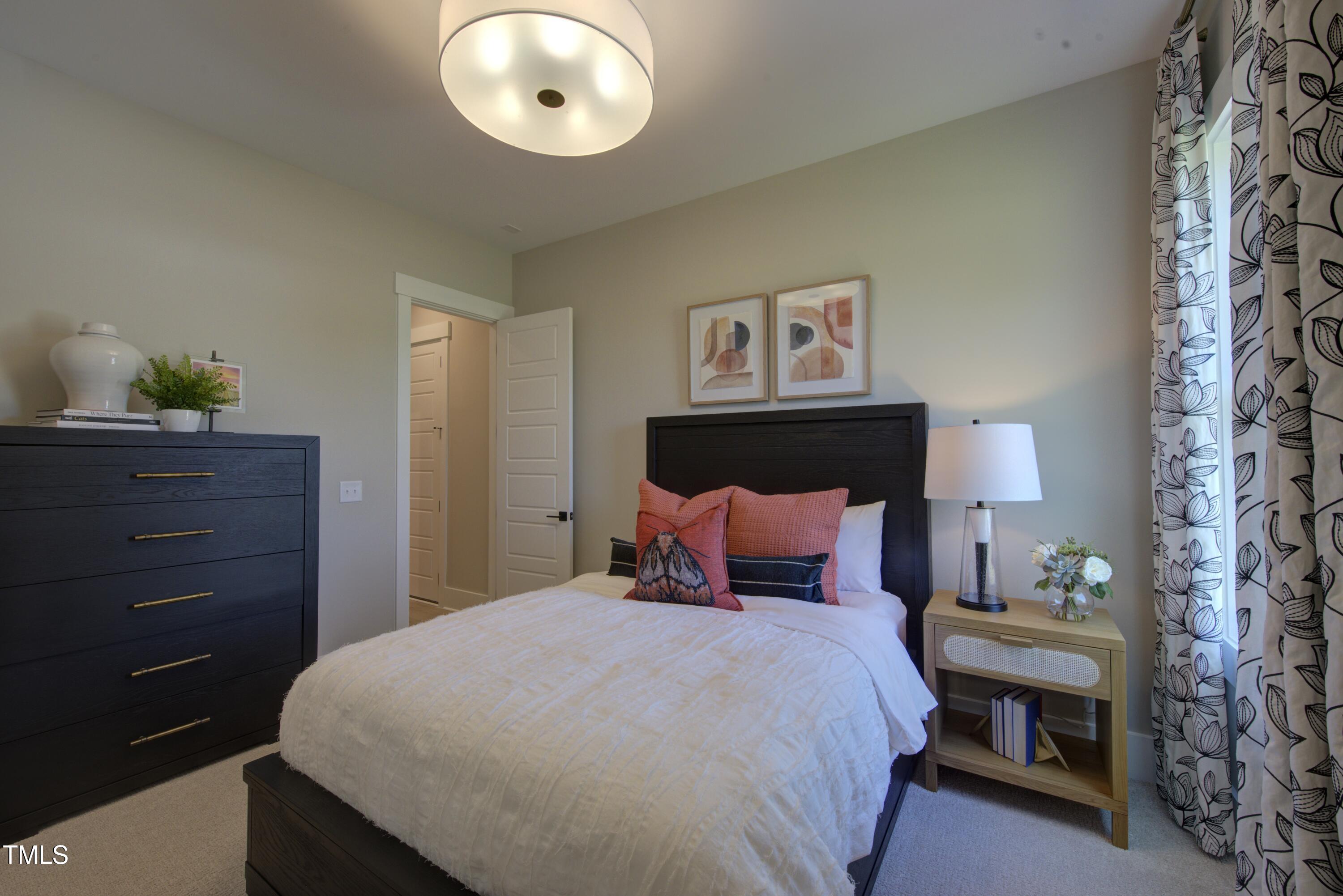 306 Golden Leaf Farms Road Angier, NC 27501 - Photo 19 of 21 a bedroom with a bed and a chandelier