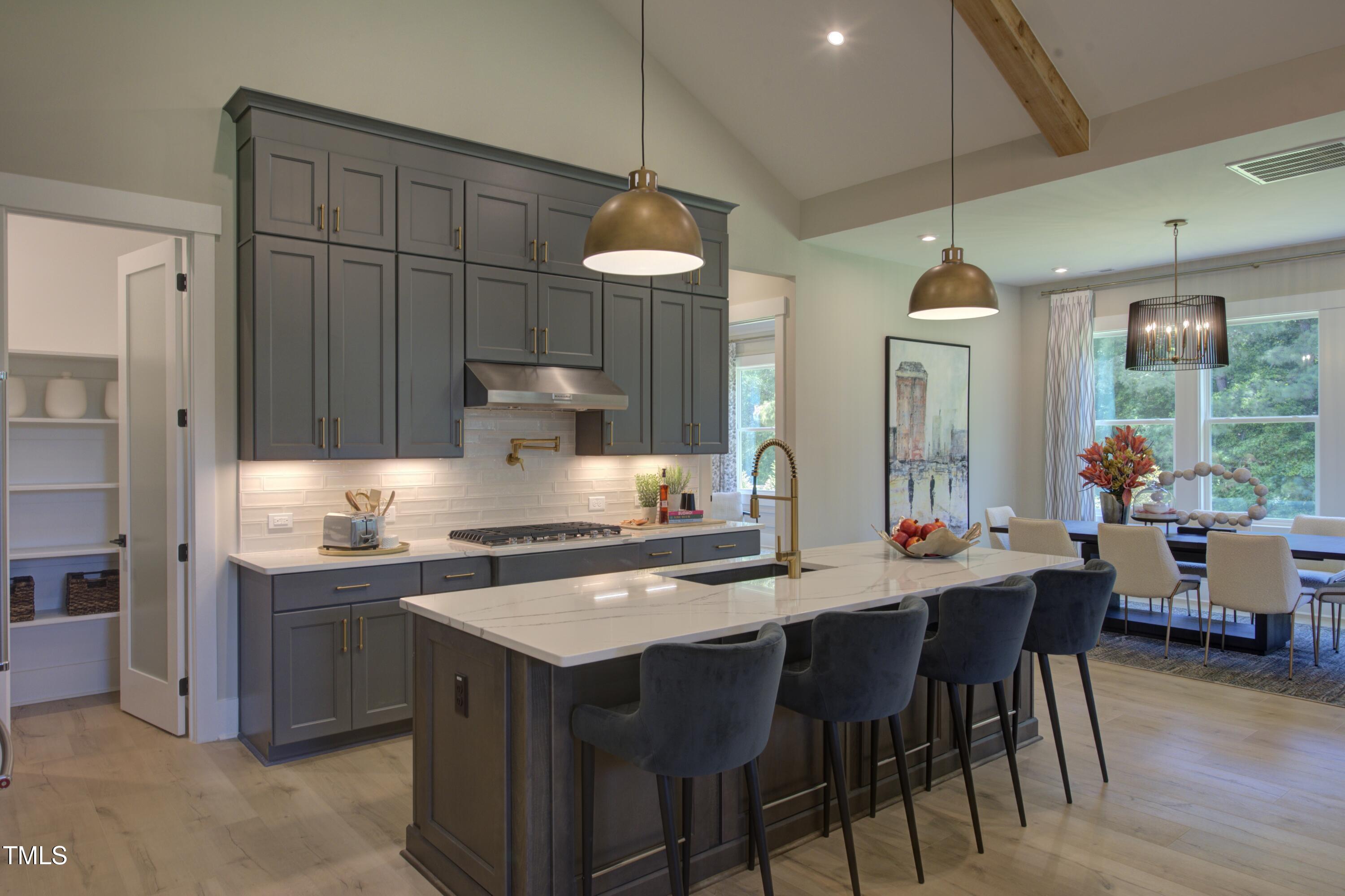 306 Golden Leaf Farms Road Angier, NC 27501 - Photo 6 of 21 a kitchen with stainless steel appliances a table and chairs in it
