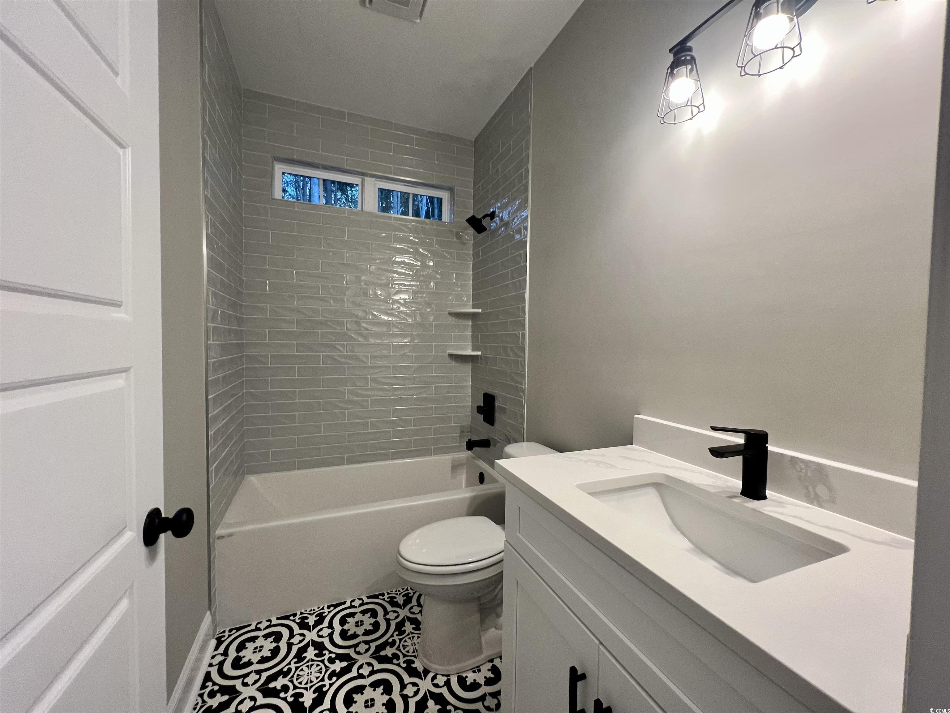 1107 Highway 9 Business Loris, SC 29569 - Photo 19 of 33 Full bathroom featuring tile patterned flooring, tiled shower / bath combo, toilet, and vanity