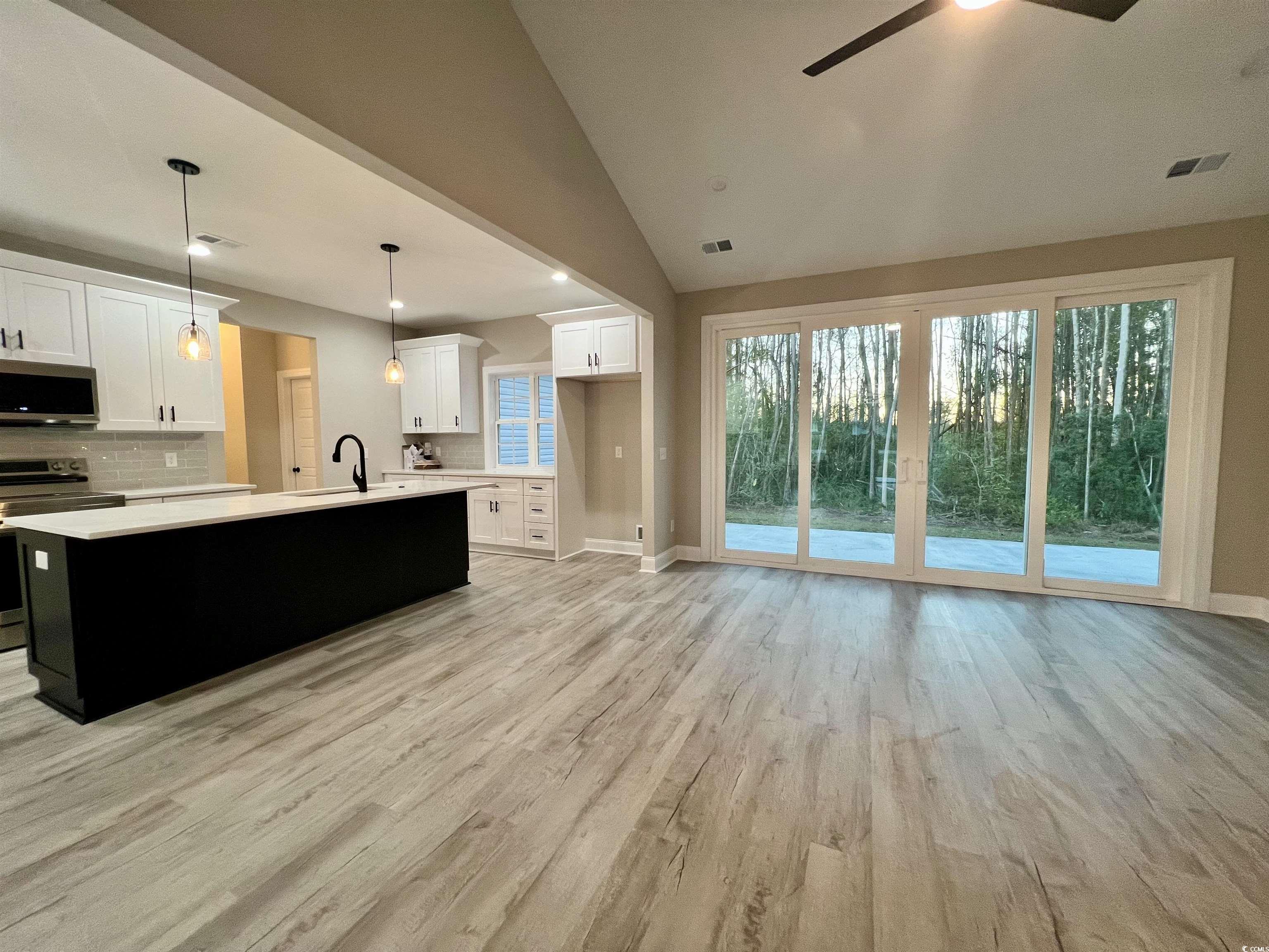 1107 Highway 9 Business Loris, SC 29569 - Photo 5 of 33 Kitchen with pendant lighting, light hardwood / wood-style flooring, vaulted ceiling, white cabinetry, and stainless steel appliances