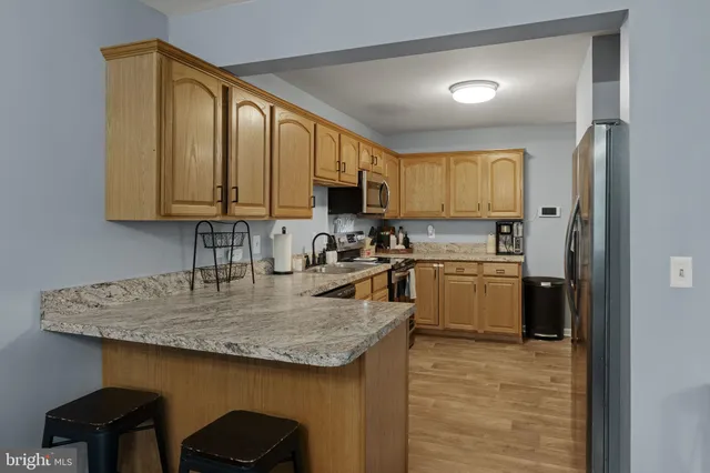 a kitchen with a sink a counter top space cabinets and stainless steel appliances