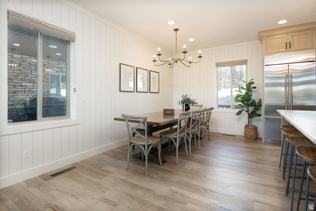 382 Ridgeview Street, Unit 8 & 9 Brian Head, UT 84719 - Photo 14 of 52 Dining area featuring plank-style wood-finish flooring, white shiplap wall paneling, a bronze chandelier, recessed lighting, and a window with a roller shade