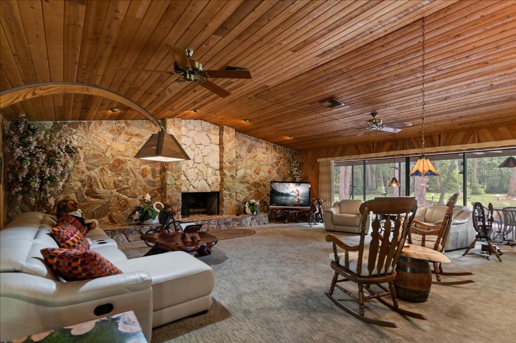 935 Ranch Road Tarpon Springs, FL 34688 - Photo 11 of 40 a living room with furniture a fireplace and a table
