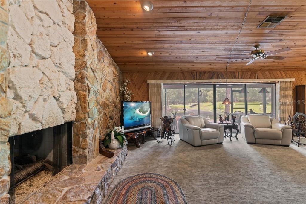 935 Ranch Road Tarpon Springs, FL 34688 - Photo 13 of 40 a living room with furniture a flat screen tv and a fireplace