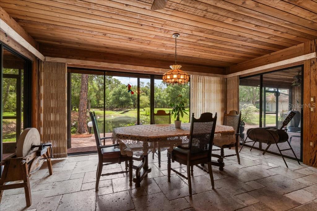 935 Ranch Road Tarpon Springs, FL 34688 - Photo 16 of 40 a view of a dining room with furniture and floor to ceiling window